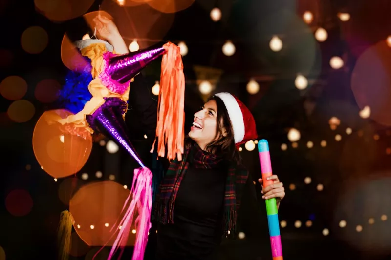 Por qué se celebran las posadas (Mujer sostiene una piñata)