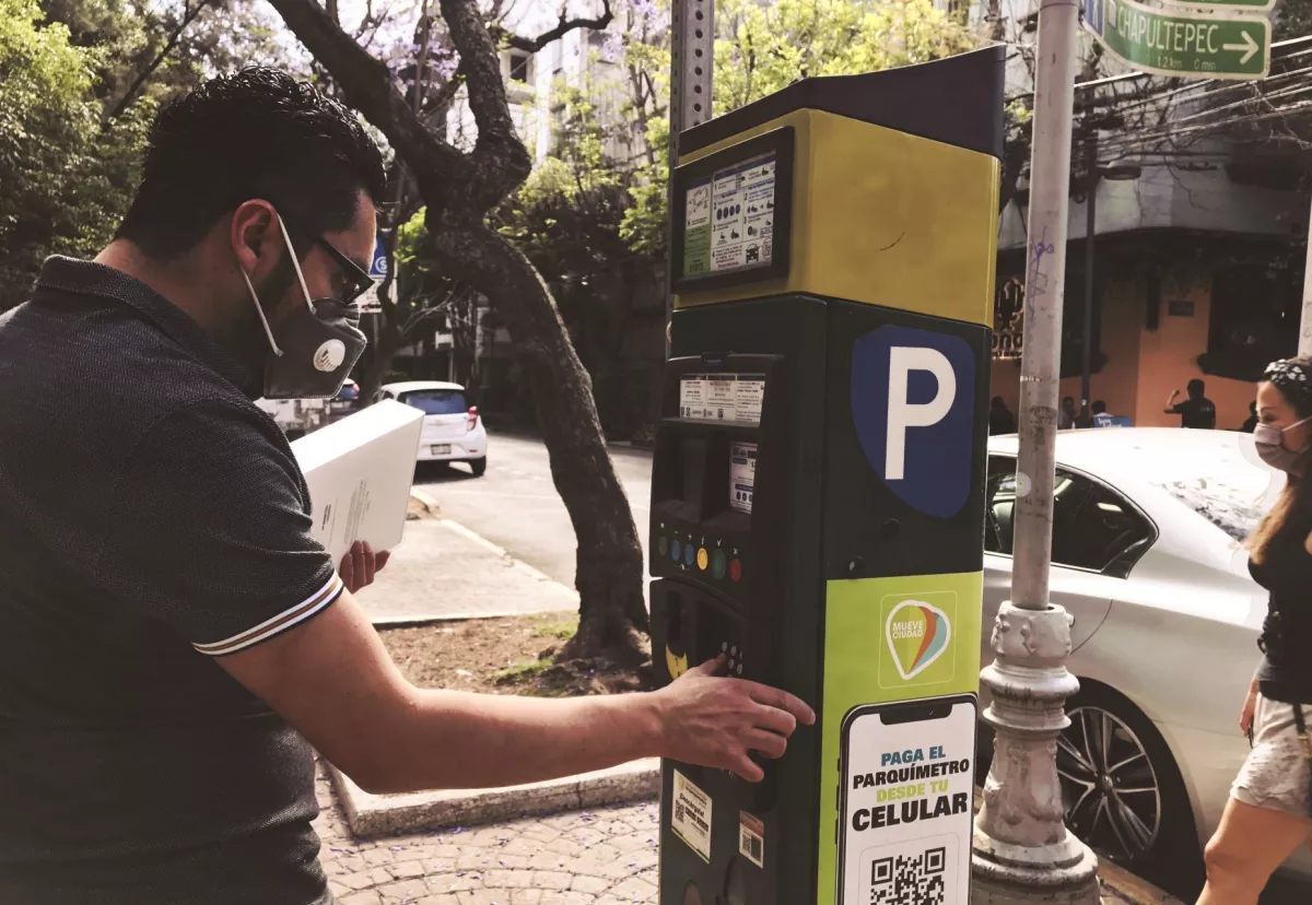 persona pagando parquímetro de estacionamiento en cdmx