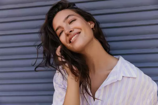 Pretty,Young,Caucasian,Woman,Looking,Into,Distance,Smiling,Corrects,Her