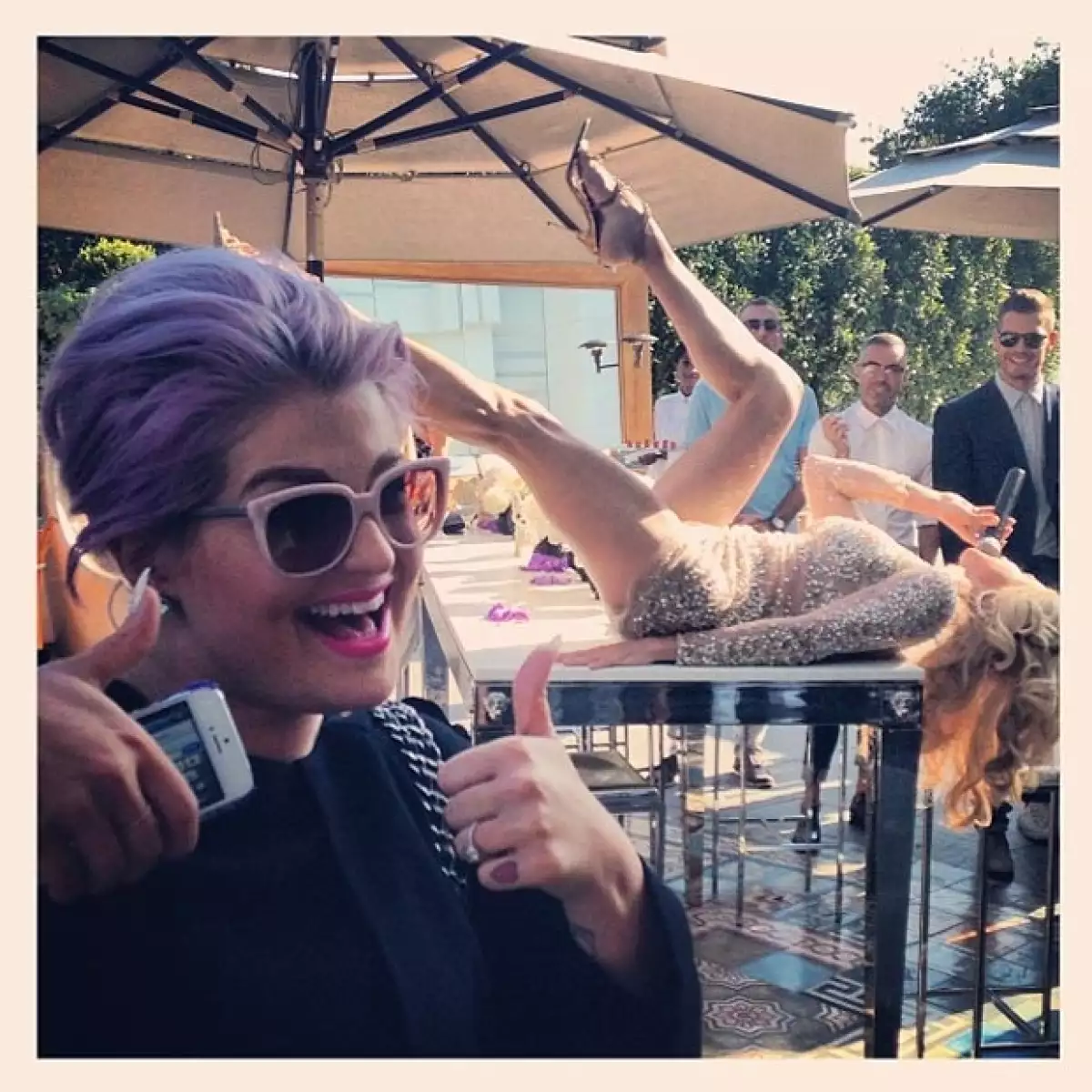 Kelly Osbourne es testigo del performance de un imitador de Fergie en una foto que compartió su compañero George Kotsiopoulos.