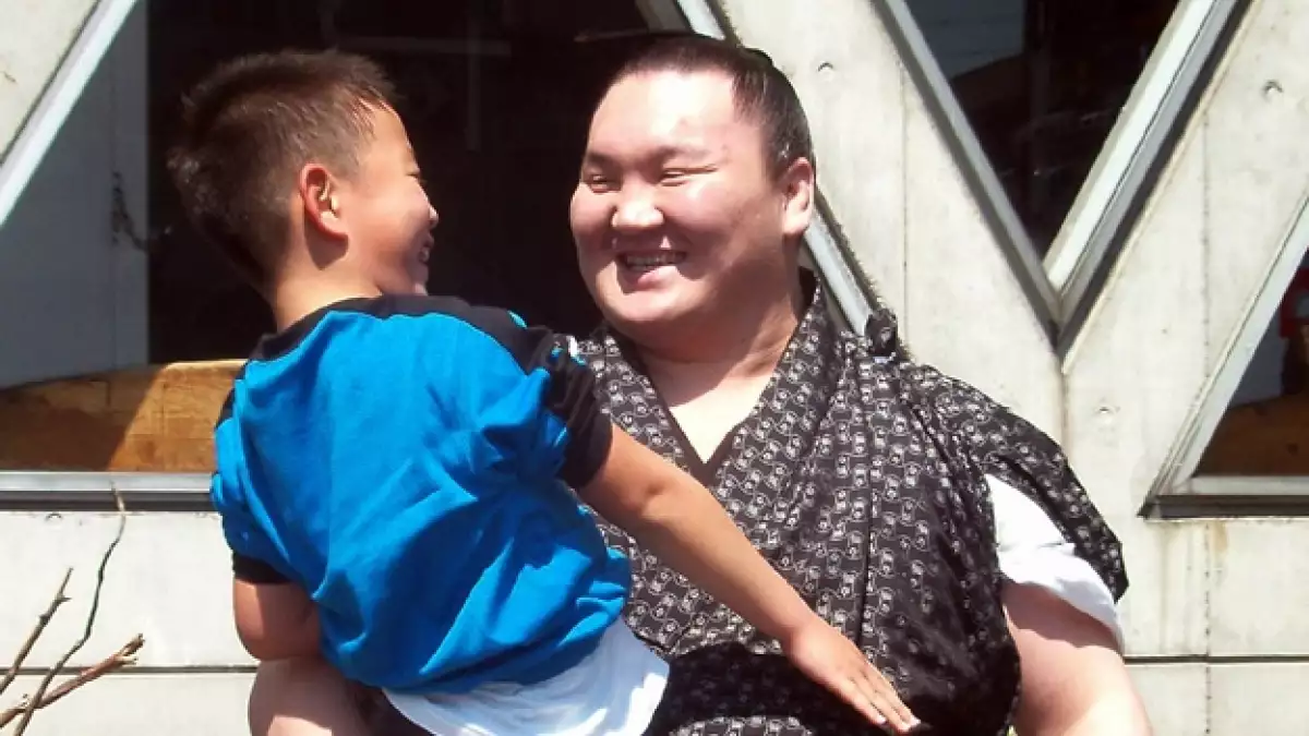 un luchador de sumo visita a un refugio en sendai