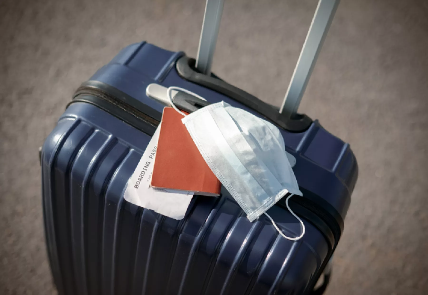 suitcase, passport and medical mask