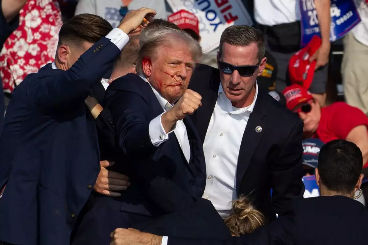 El candidato republicano estadounidense Donald Trump es visto con sangre en la cara rodeado de agentes del servicio secreto mientras lo sacan del escenario en un evento de campaña en Butler Farm Show Inc. en Butler, Pensilvania, el 13 de julio de 2024.