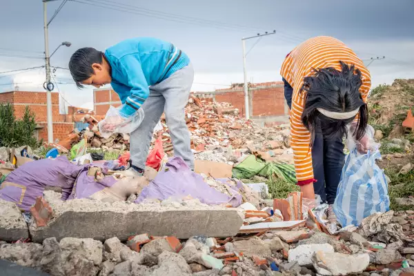 two latin kids recycling and cleaning up garbage in their city in latin america, bolivia - garbage recycling concept