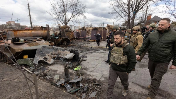El presidente de Ucrania, Volodimir Zelenski, camina junto a vehículos militares rusos destruidos en la ciudad de Bucha, Ucrania.