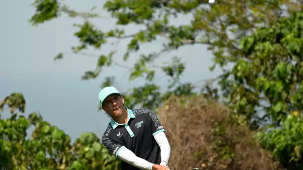 Foto del golfista Carlos Ortiz tras hacer un tiro con el palo de golf en la mano y la pequeña pelota blanca volando