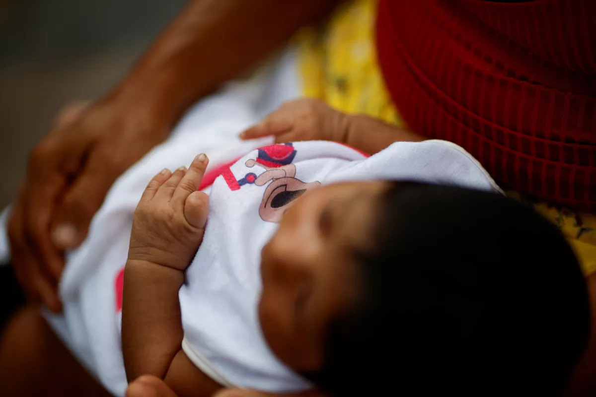 Edinez Boro Munduruku sostiene a su hija durante una misión de investigadores del instituto brasileño de salud pública Fiocruz para investigar trastornos de salud entre los indígenas Munduruku que están potencialmente vinculados a la contaminación por mercurio causada por la minería ilegal de oro, en la aldea de Sai Cinza, en el municipio de Jacareacanga, estado de Para, Brasil 20 de febrero de 2025