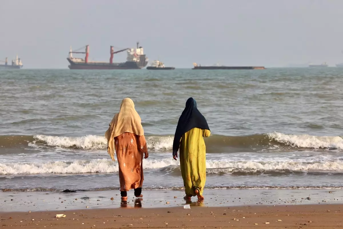 Los iraníes disfrutan de la orilla del mar mientras se ven barcos en el Estrecho de Ormuz frente a Bandar Abbas, en el sur de Irán, el 10 de agosto de 2026.