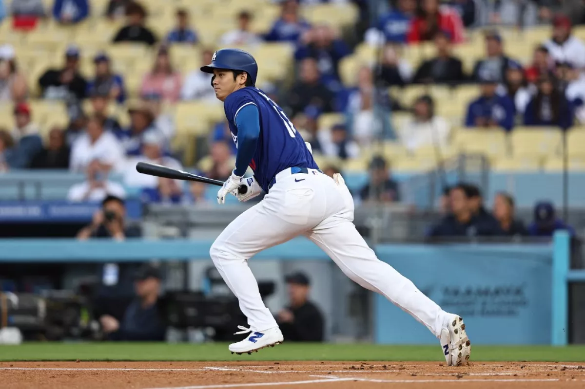 foto de shohei ohtani corriendo con el bat en mano en un juego de los dodgers