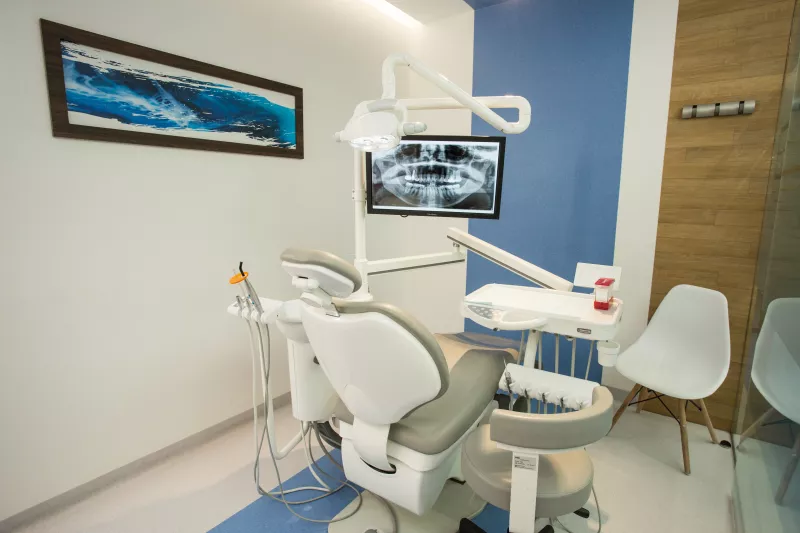 Consultorio dental con sillas y sillón para atender a pacientes.
