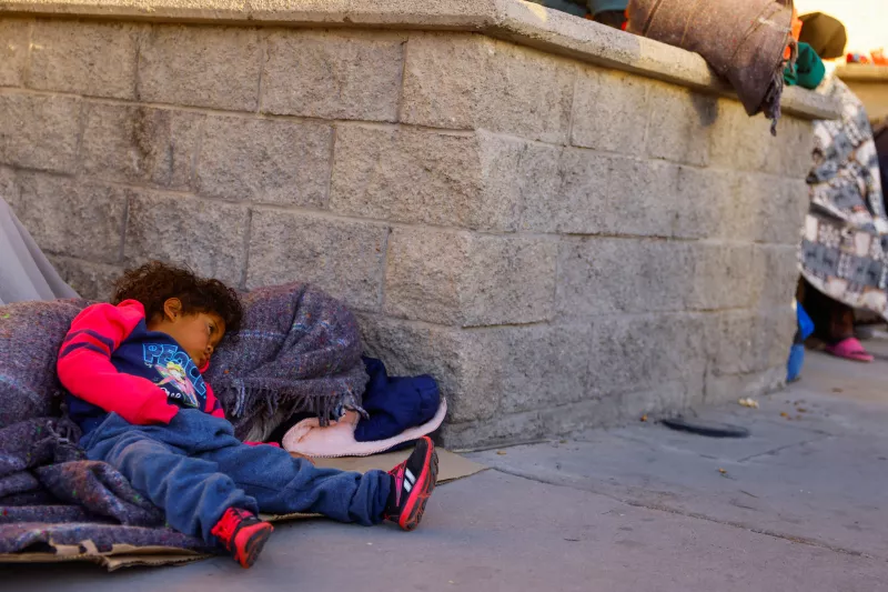 A child rests outside the migrant detention center where several migrants died after a fire broke out late on Monday, in Ciudad Juarez