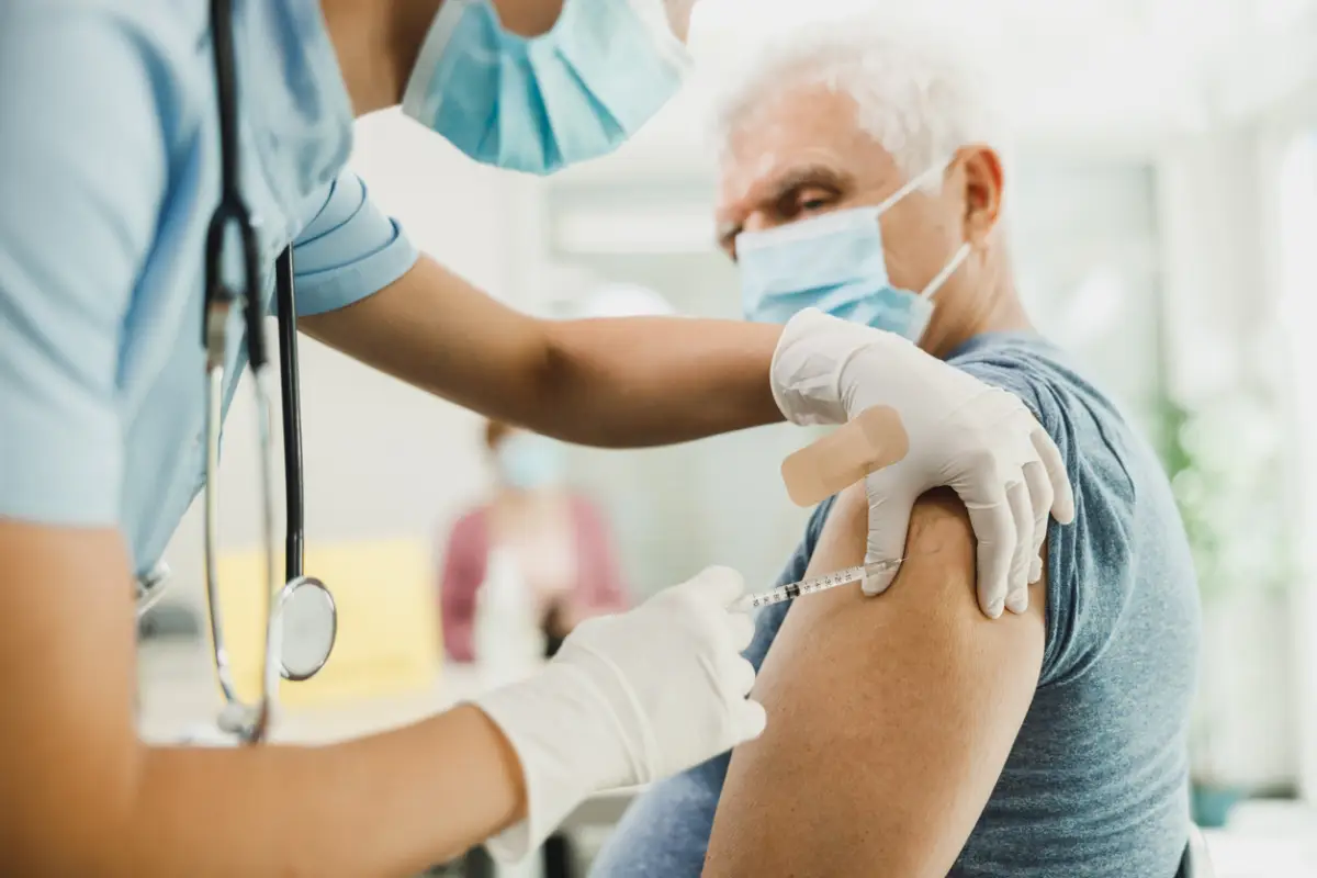 Una enfermera le da una vacuna a un hombre mayor debido a la pandemia de coronavirus.
