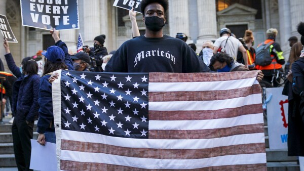 A man holds a U.S. flag during a rally at the New York Public Library, the day after Election day, in Manhattan