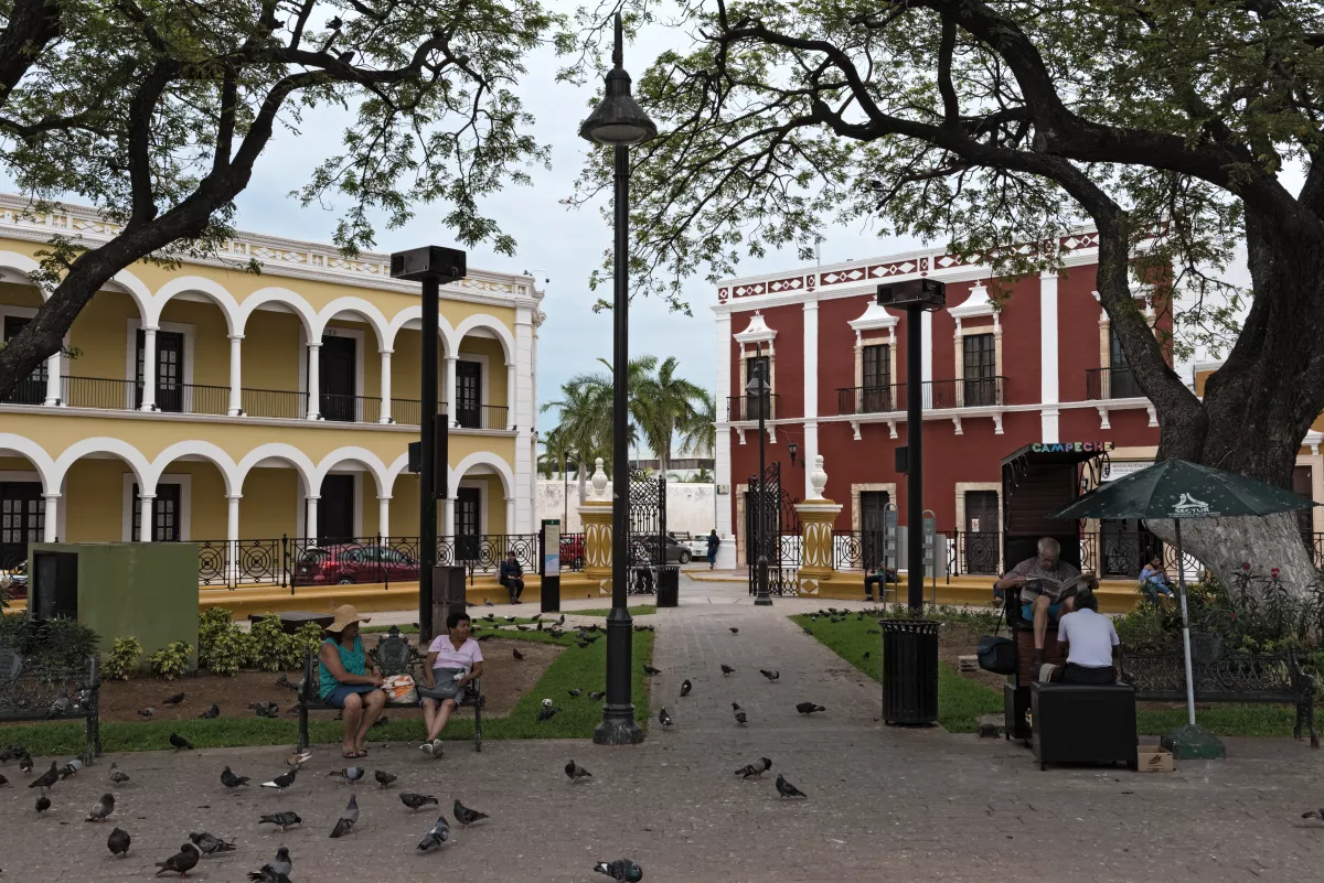 shoe cleaner and restless walkers in independence park in the old town of campeche, mexico