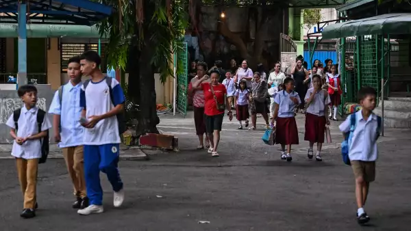 Los padres acompañan a sus hijos mientras las clases se abren para el nuevo año escolar en una escuela primaria en Manila el 8 de junio de 2026.
