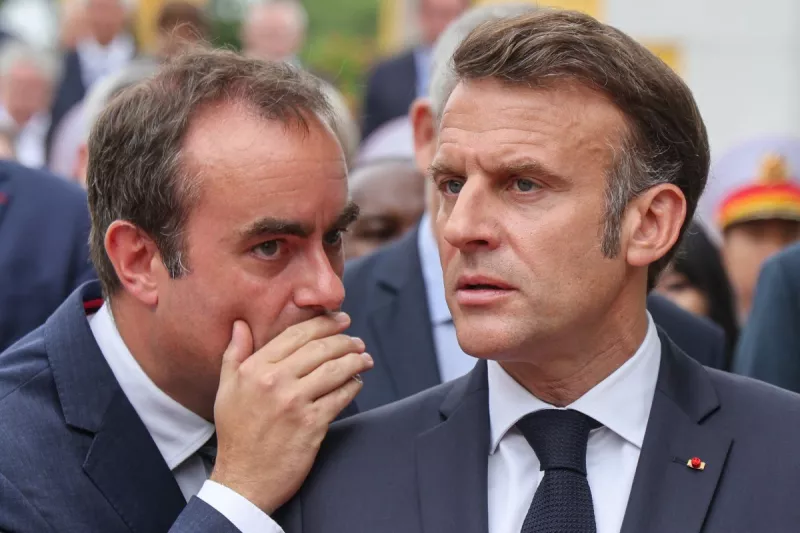 El presidente de Francia, Emmanuel Macron (R), habla con el ministro de las Fuerzas Armadas de Francia, Sebastien Lecornu (L), después de participar en una ceremonia de colocación de coronas en el monumento de héroes y mártires nacionales en Hanoi el 26 de mayo de 2025.
