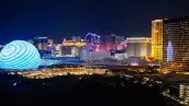 Foto panorámica de Las Vegas por la noche con la ciudad completamente iluminada.