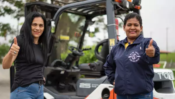 Dos mujeres lucen contentas en un centro de distribución de AB InBev