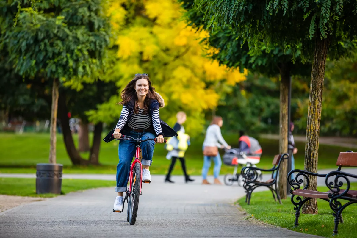 Urban biking - woman riding bike in city park