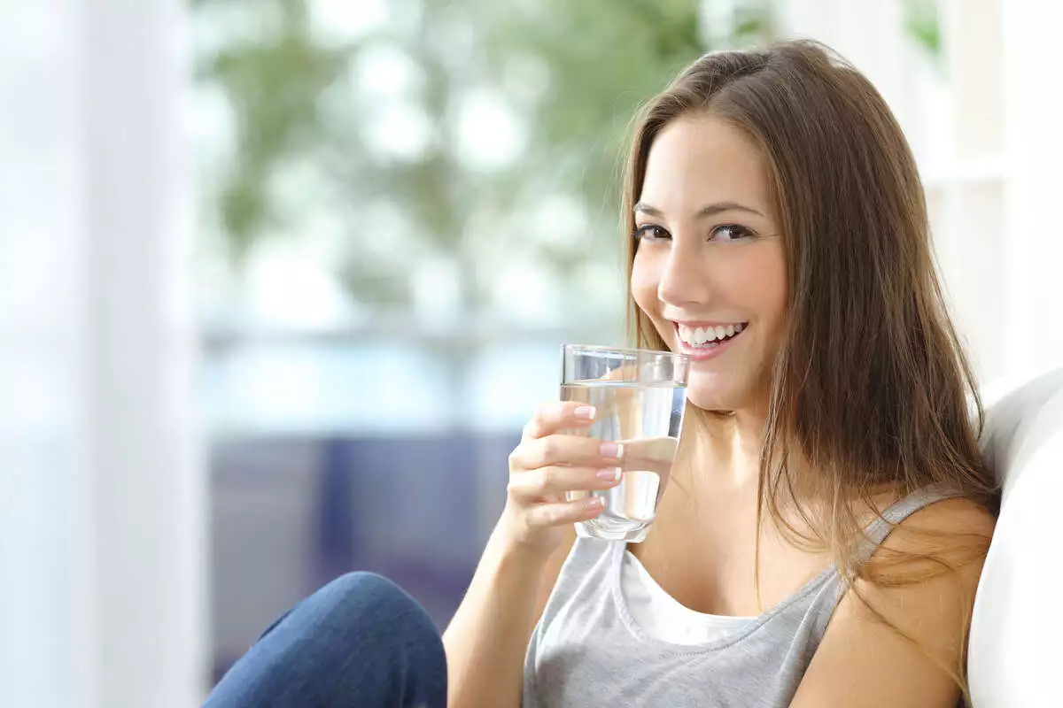 Girl,Drinking,Water,Sitting,On,A,Couch,At,Home,And