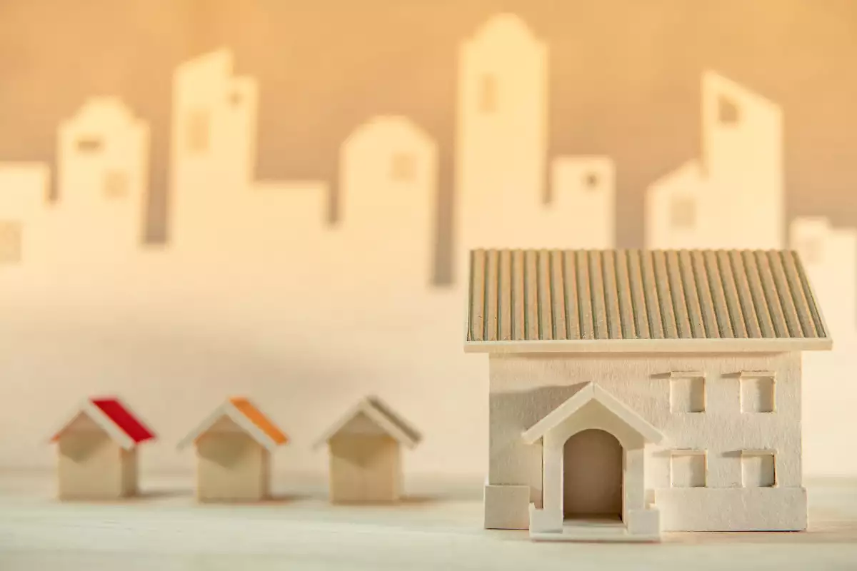 Real estate or property investment. Home design concept. House models on the table with city skyline background. Residential building development