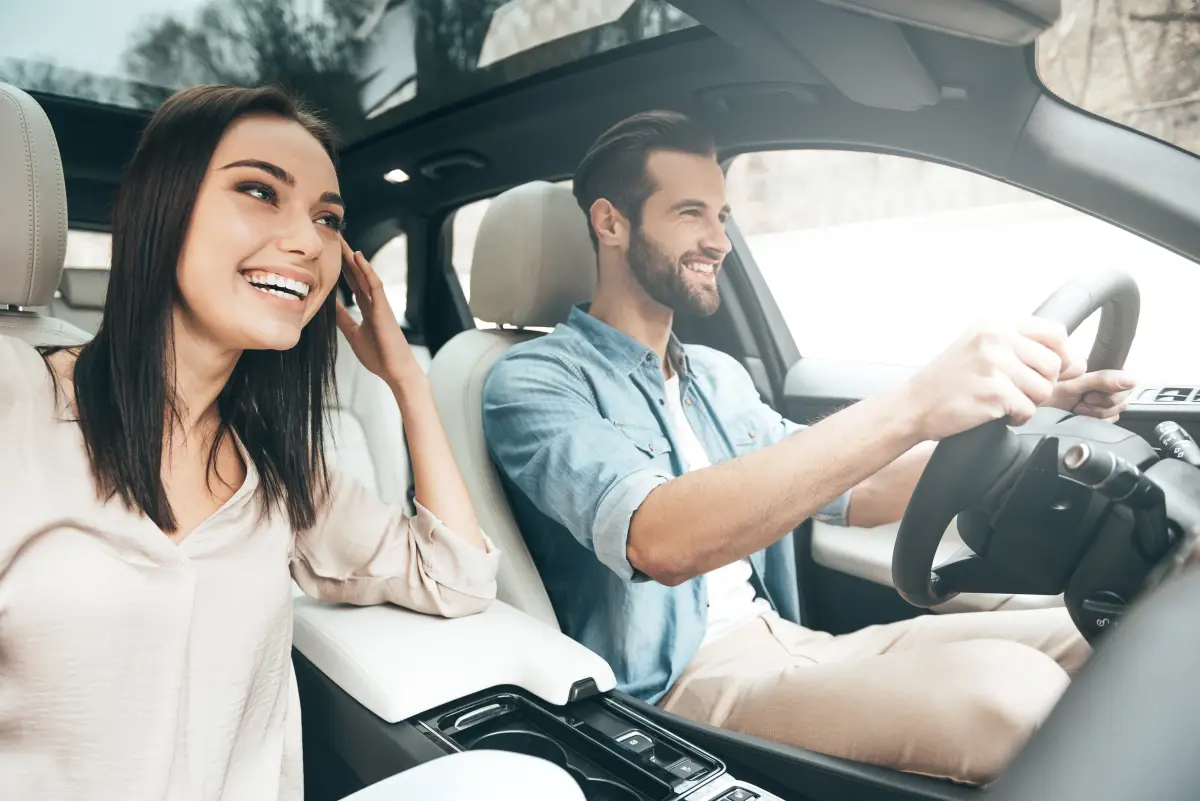 Una pareja disfruta su viaje en auto. 