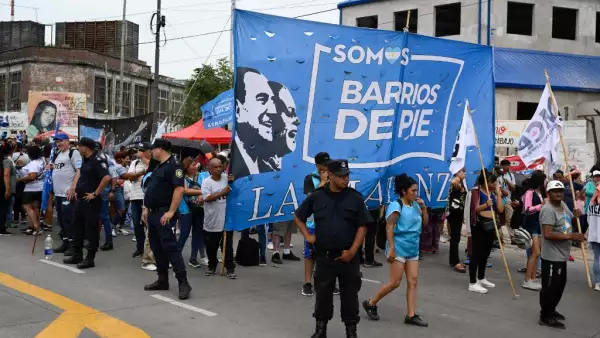 Oficiales de policía están de guardia en una calle mientras miembros de organizaciones sociales protestan contra el decreto de emergencia del presidente argentino Javier Milei en La Matanza, provincia de Buenos Aires, Argentina, el 28 de diciembre de 2023.