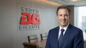 José Antonio Meade vestido con un traje azul al lado del logo de grupo Gigante.