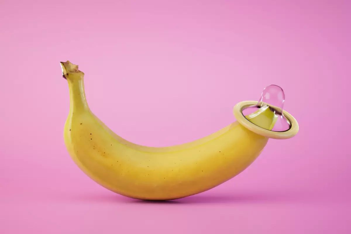 a condom worn on the tip of a banana on a pastel background. 3D render
