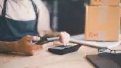 Imagen del un encargado de un negocio pyme haciendo cuentas con calculadora