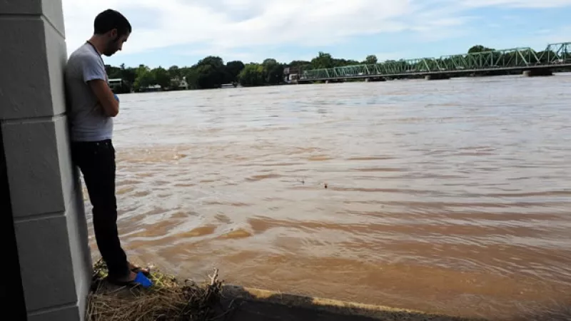 Un hombre mira la crecida de un río en el noreste de EU