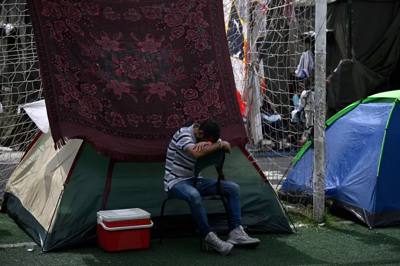 Un hombre desplazado después de los terremotos gemelos del 24 de junio toma una siesta en una silla en un campamento improvisado en el complejo deportivo José María Vargas en Maiquetia, estado de La Guaira, Venezuela, el 30 de junio de 2026. 