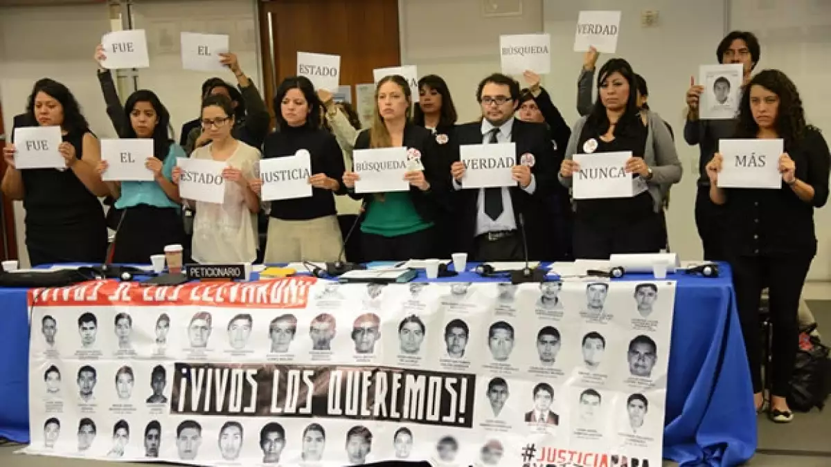 Manifestantes muestran imágenes de los 43 desaparecidos en sesión de la CIDH