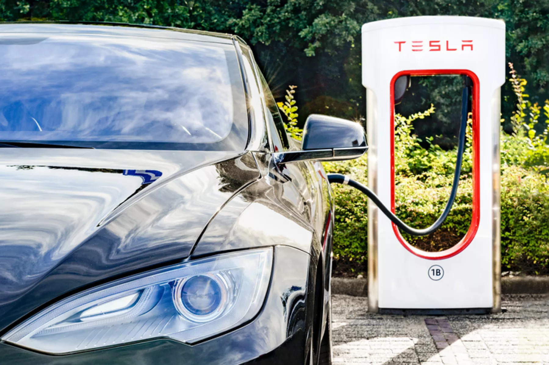 Tesla Model S al lado de un cargador de Tesla
