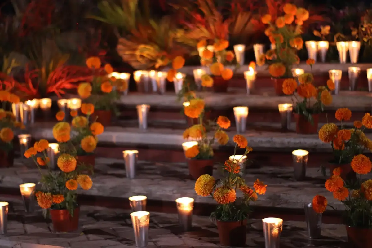 Ofrenda de día de muertos con flor de cempasúchil y celas blancas