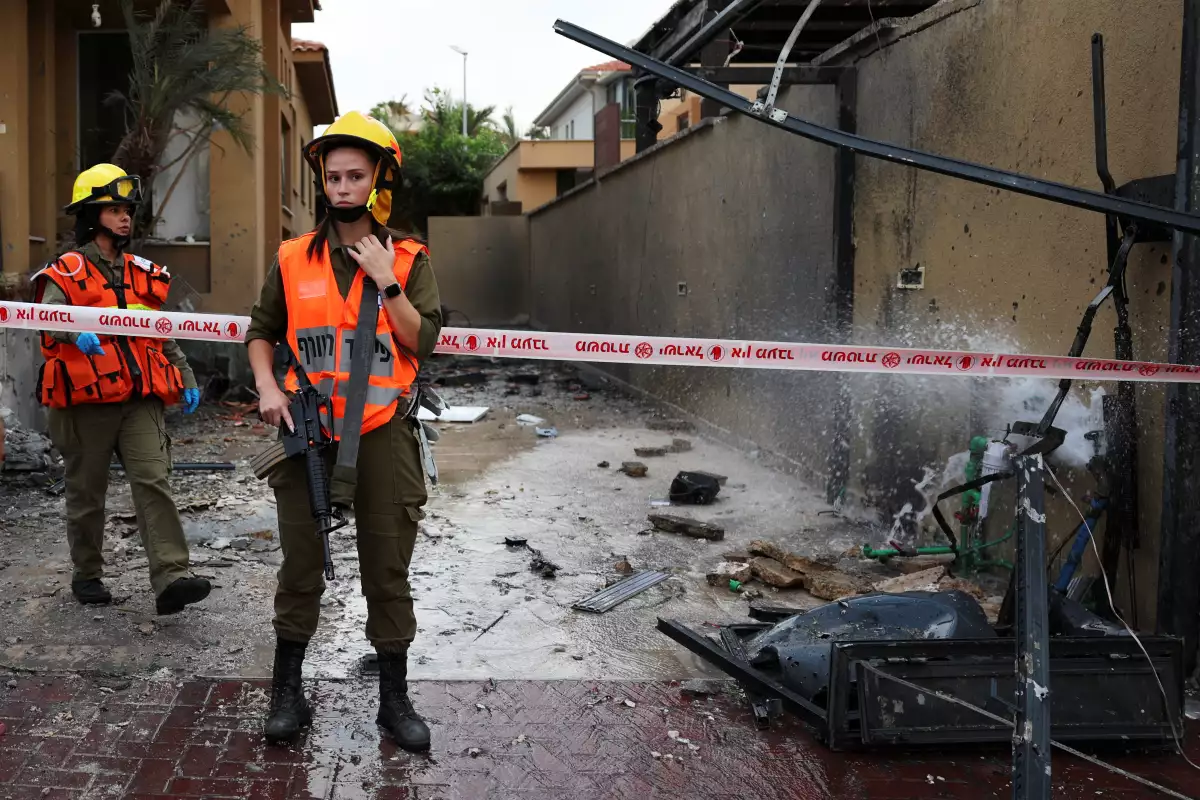 Los soldados de Israel vigilan cerca de los daños causados por un cohete después de que se disparara desde la Franja de Gaza hacia Israel, en Ashkelon, al sur de Israel, el 9 de octubre de 2023. 