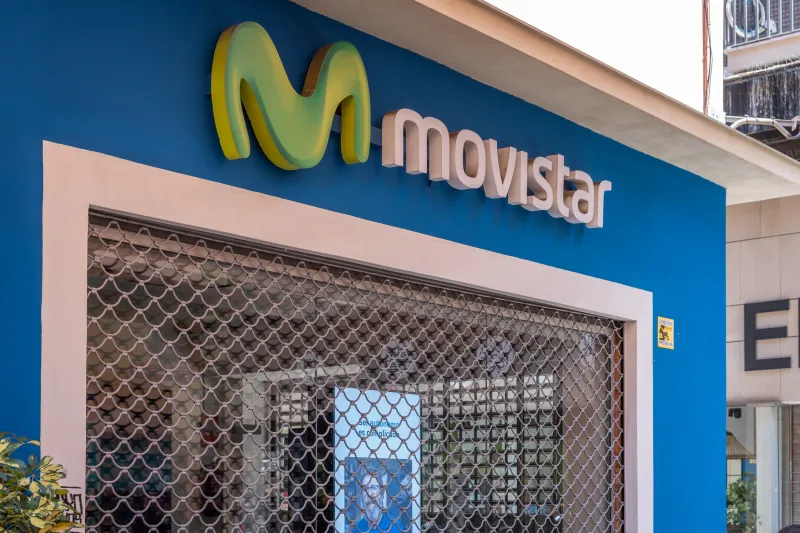 Fachada azul de una tienda de servicio al cliente de Movistar con el logo de la empresa