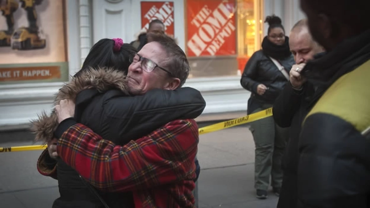 Dos personas se abrazan luego de que se registrara un tiroteo en un Home Depot de Nueva York