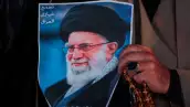 Un hombre musulmán chiíta sostiene un cartel del difunto líder supremo iraní Ayatolá Ali Khamenei, asesinado en un ataque estadounidense-israelí contra Teherán, y un conjunto de cuentas de oración durante un mitin en la Plaza Tahrir, en Bagdad, el 6 de marzo de 2026.
