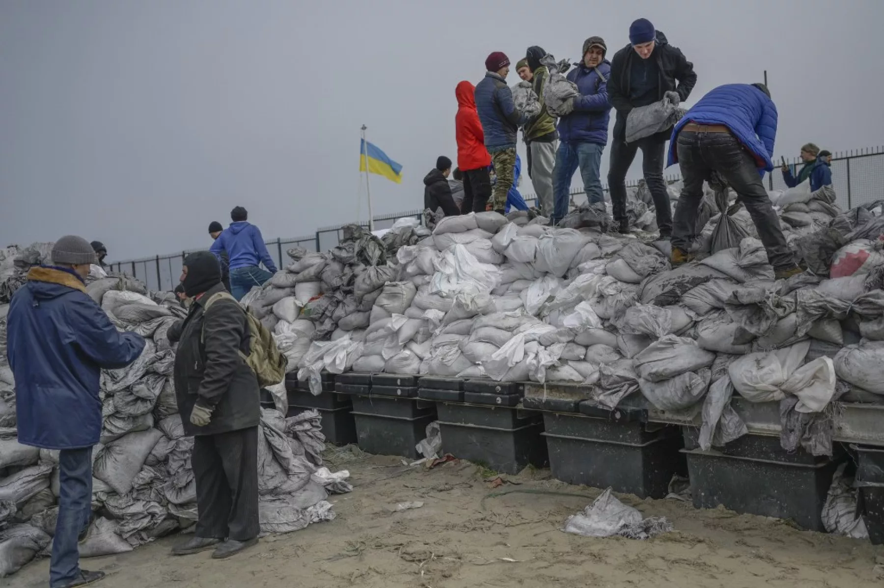 Ciudadanos llenan bolsas de arena para las trincheras en la playa del Mar Negro en Odessa, en el sur de Ucrania. 