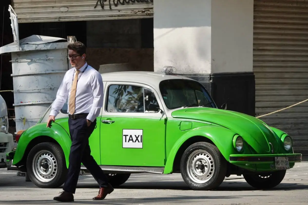 Volkswagen Sedán conocido como Vocho, acondicionado como taxi de la Ciudad de México, con carrocería en color verde y blanco. El automóvil aparece estacionado en una calle de México y conserva el diseño clásico de este modelo.