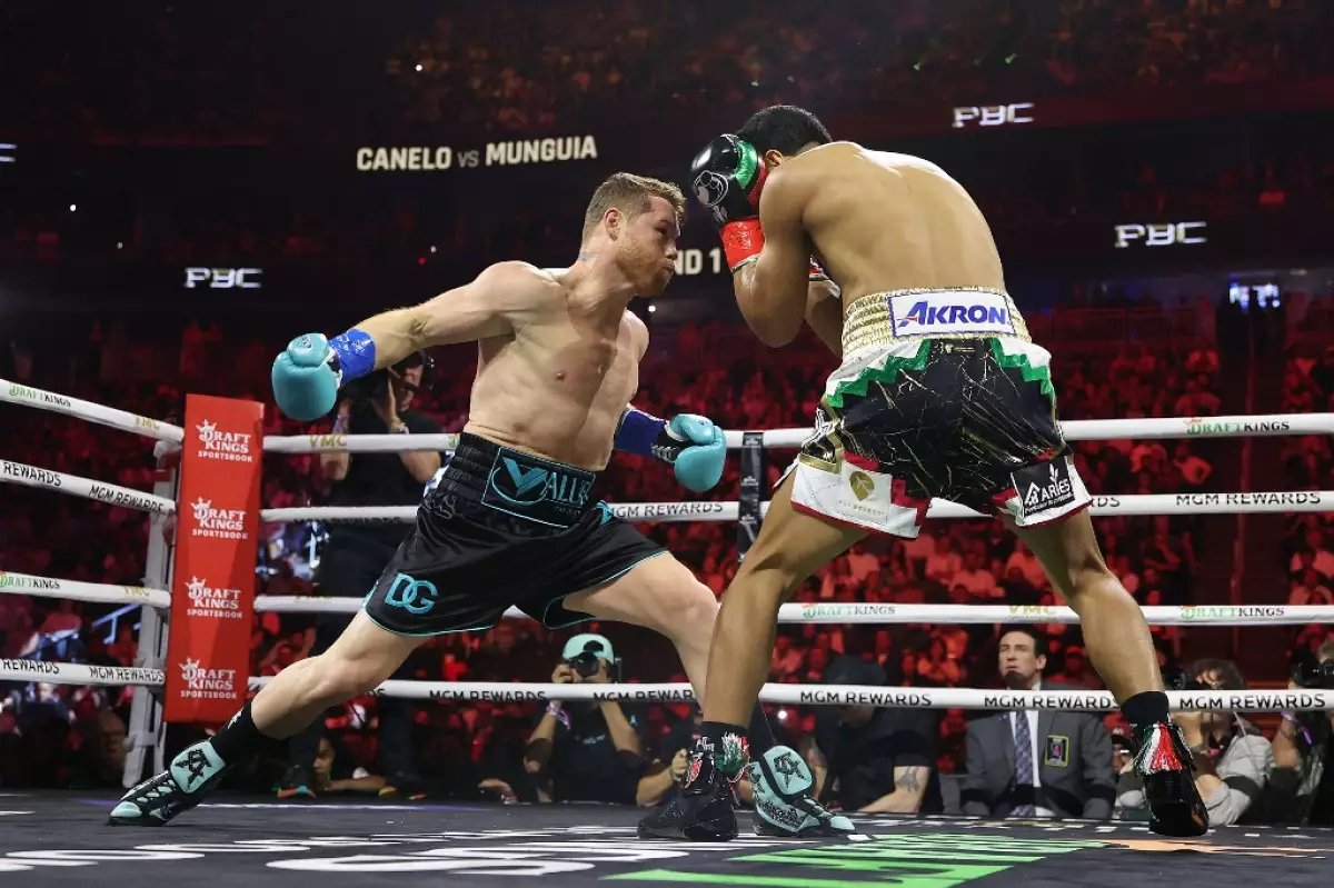 foto de canelo alvarez dando un derechazo a jaime munguia en el ring