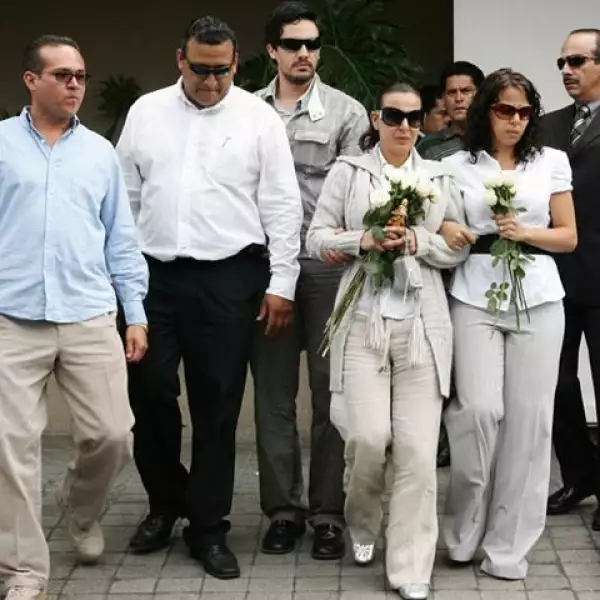 El grupo salió de la capilla, la mamá traía tres rosas en la mano.