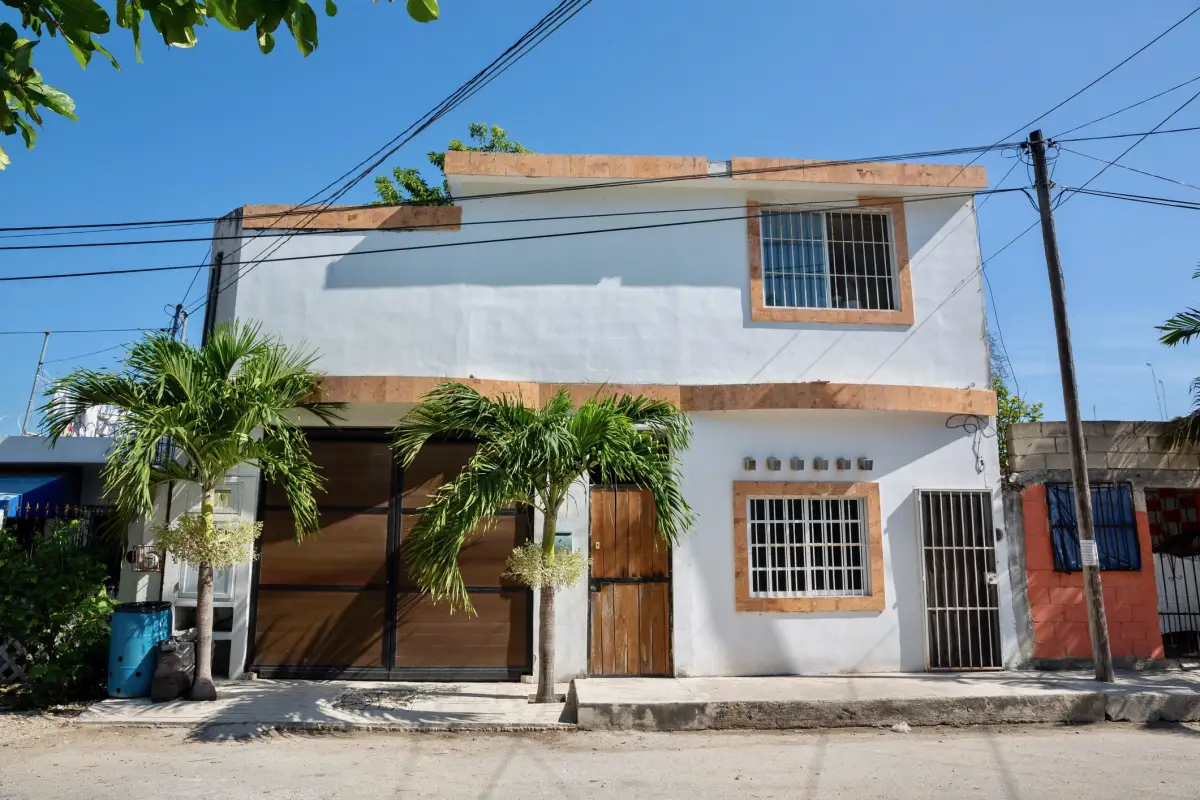 Fotografía de la fachada de una casa blanca en una calle de Tulum, Riviera Maya. 