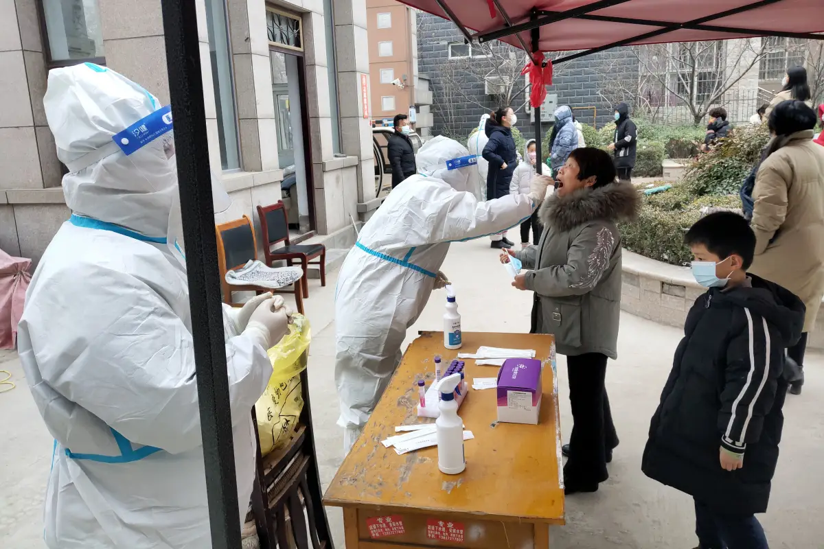 Residentes de la ciudad de Anyyang, bajo confinamiento desde el martes, se forman para que les tomen una muestra para una prueba de COVID-19. 