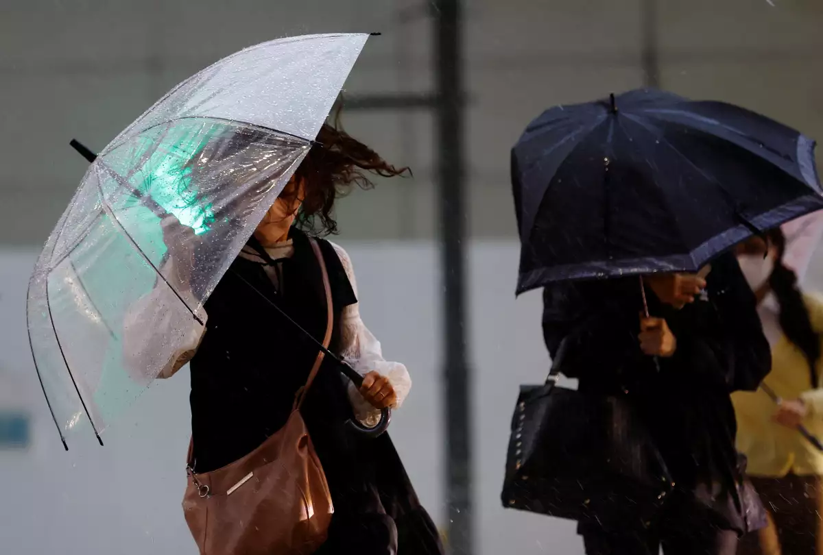 Los peatones que sostienen paraguas se abren camino bajo la fuerte lluvia en Tokio, Japón, el 2 de junio de 2023