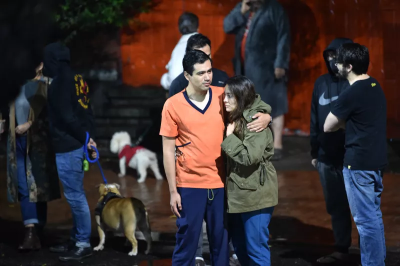 Personas afuera de su edificio aguardan a que pase el sismo.