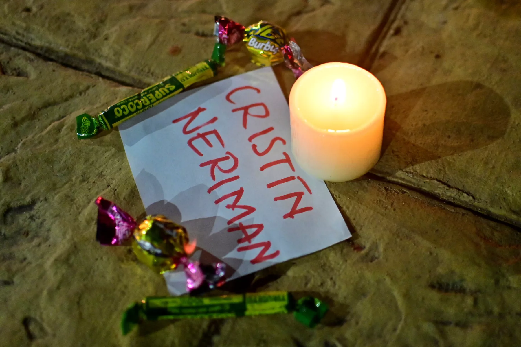 Un pedazo de papel con el nombre de uno de los niños desaparecidos se ve mientras la gente se reúne para encender velas en oración, durante la búsqueda de niños sobrevivientes de un avión Cessna 206 que se estrelló en las selvas de Caqueta, en San José del Guaviare, Colombia, el 21 de mayo de 2023.