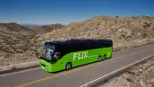 En una carretera con zonas áridas, un camión de Flix conduce.