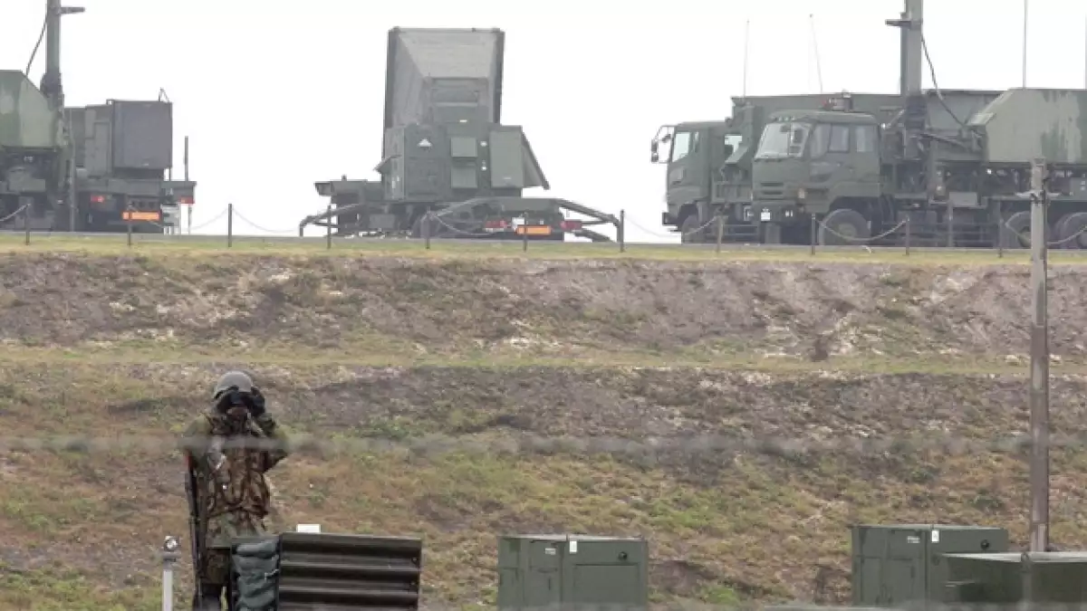 un soldado japones hace guardia ante un sistema de defensa